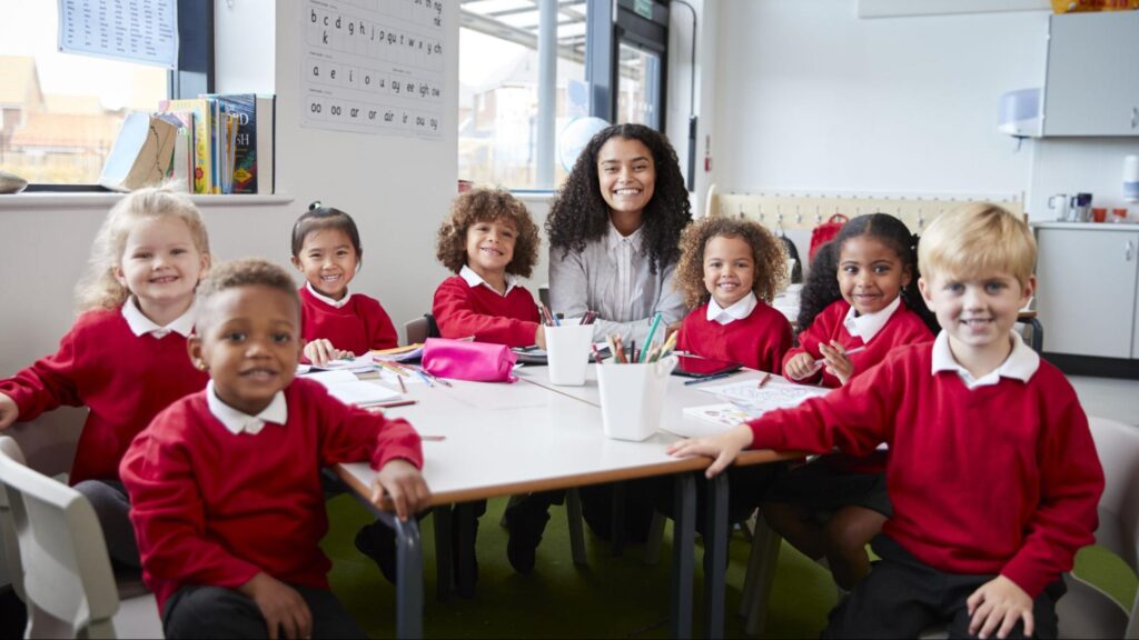 A diverse group of young students and their teacher smiling in a public school classroom in South Florida.