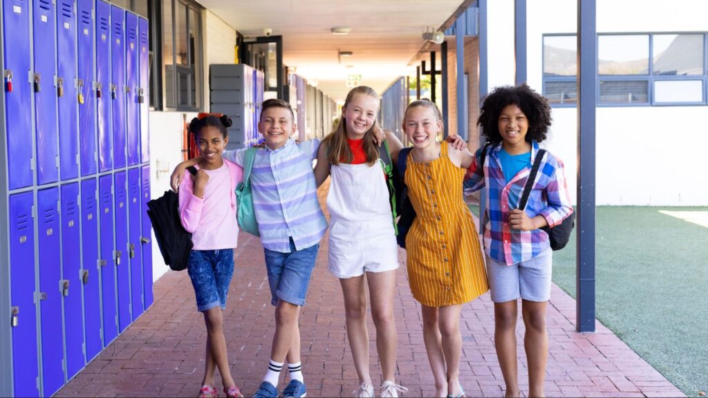 A group of middle school friends smiling and standing in front of lockers at a private school in South Florida.