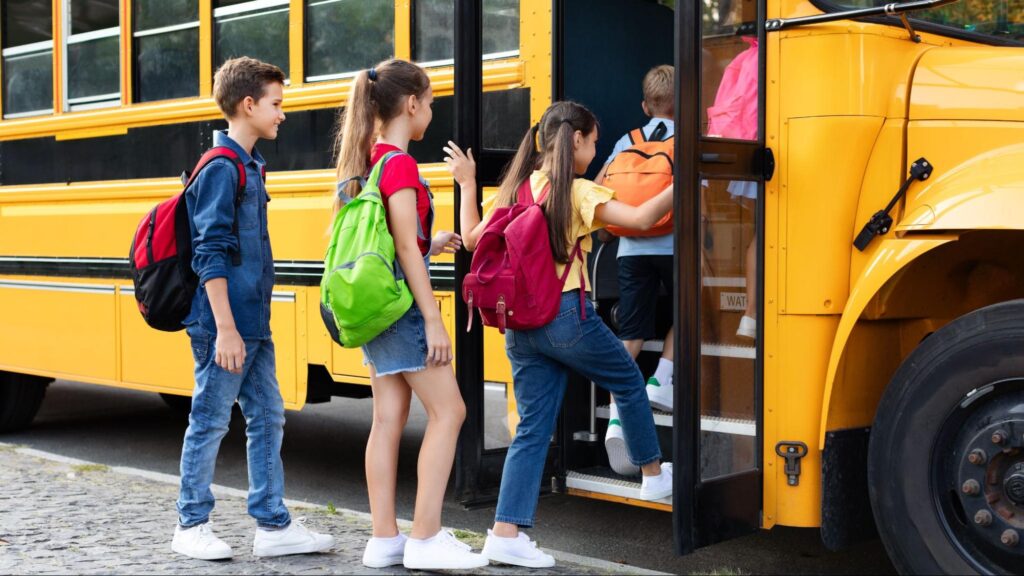Students boarding a yellow school bus in Florida, illustrating school transfers, academic continuity, and the transition process for families.
