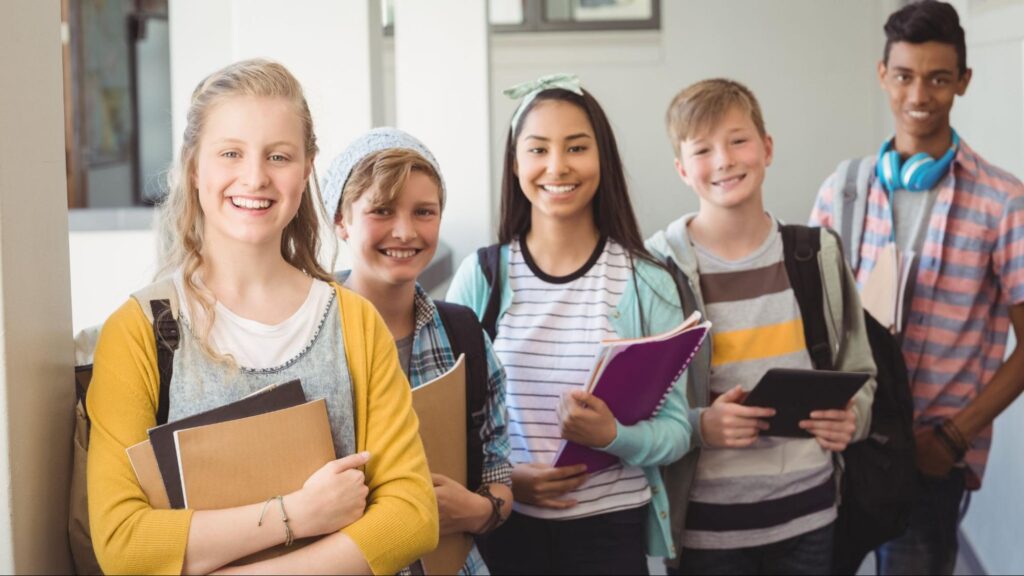 Group of middle school students in Miami standing with books and tablets, ready for academic growth and high school preparation.