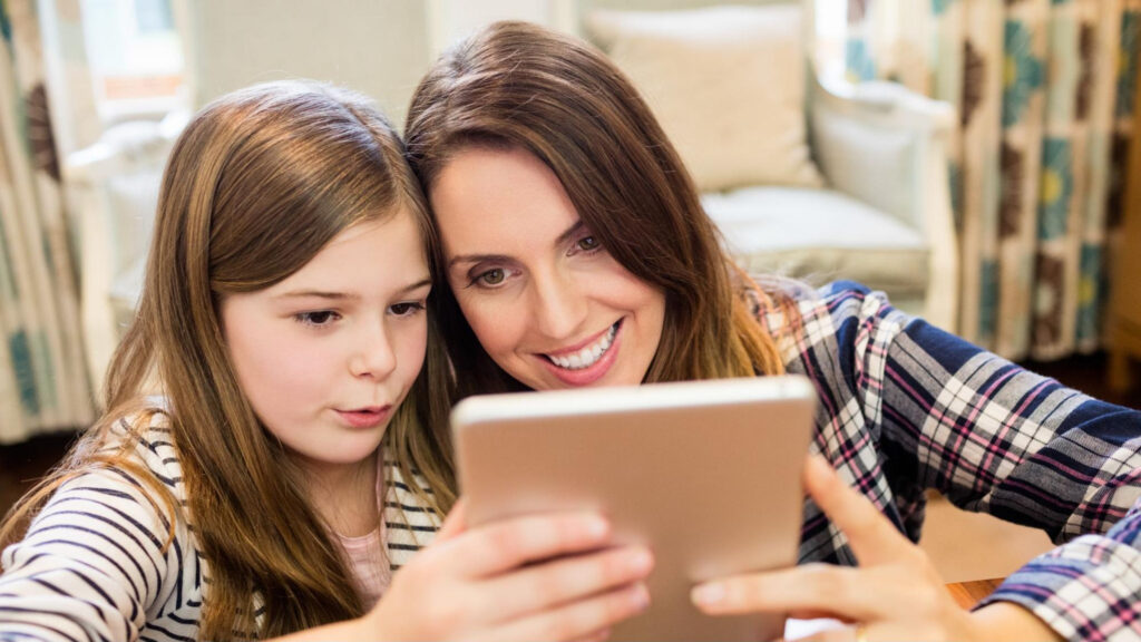 Parent and child reviewing the Carrollton School of the Sacred Heart admissions process together at home.