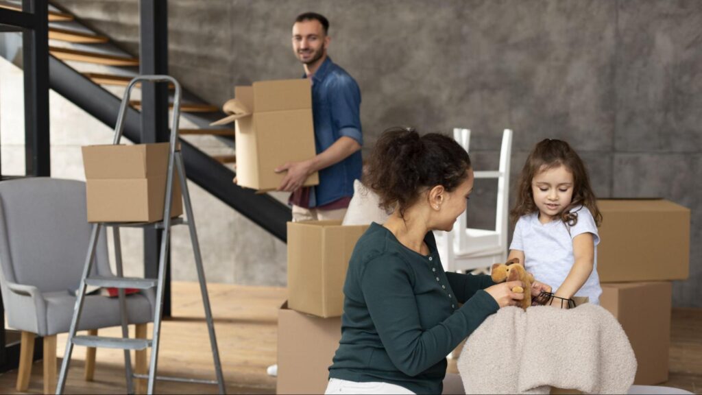 A professional family happily unpacking boxes in their new Mediterranean-style home in Coral Gables after relocating to Miami for a career opportunity.